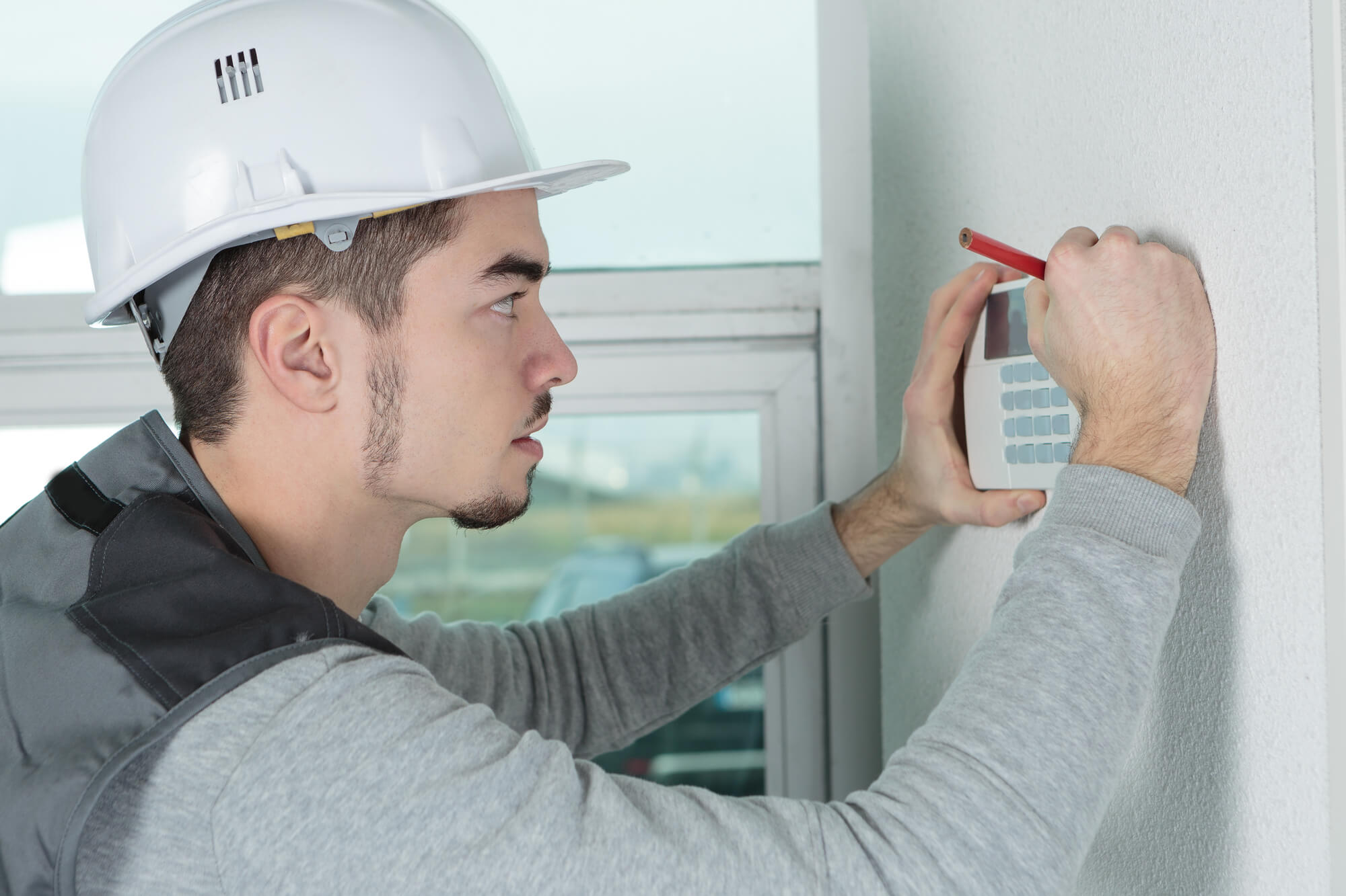 A man installing security systems in a home. 